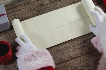 Close-up of santa claus opening scroll