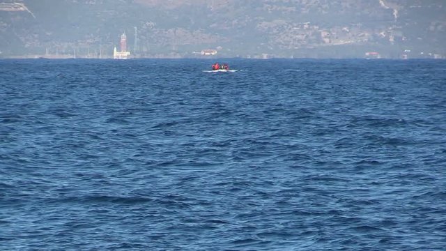 LESVOS, GREECE - NOV 2, 2015: Refugees in a rubber dinghy swim to shore from Turkey.