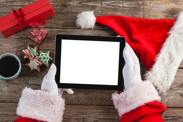 Santa claus using digital tablet on wooden plank