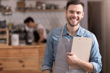 Satisfied young handsome man standing in a cafe