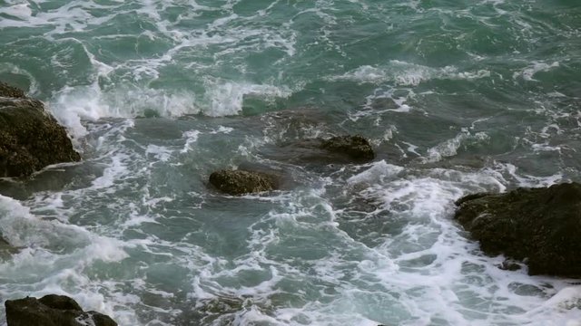 Slow motion of sea swash between boulders. Meditative view of water stream, foam, splash and textured rock. Beautiful background for amazing intro in excellent full HD clip with fourfold deceleration.