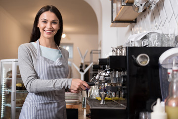 Happy pretty woman using coffee machine.