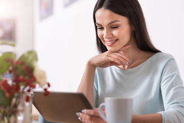 Fototapeta premium Beautiful young brunette woman using a gadget while relaxing.