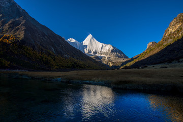 Fototapeta na wymiar Reflection of the holy snow mountain at Yading national level reserve in Daocheng County, in the southwest of Sichuan Province, China.