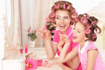 Obraz na płótnie Canvas Mother and daughter in hair curlers