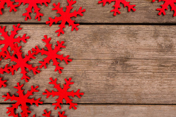 red snowflakes on wooden background with copy space