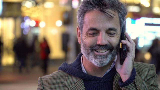 Attractive Handsome Older Man, Grey Hair Beard, Talking On Smart Mobile Cell Phone On Street In New York City. Successful Hipster Urban Businessman.