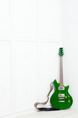 Fototapeta na wymiar guitar propped in front of a white wall