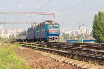 Passenger inter-city train on the background of urban developmen