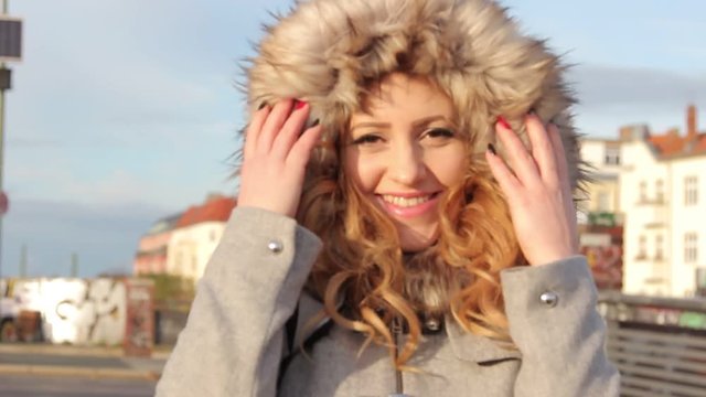 young beautiful girl in winter jacket with fur hood outdoor