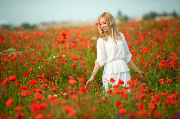 Fototapeta na wymiar beautiful girl in the poppy field