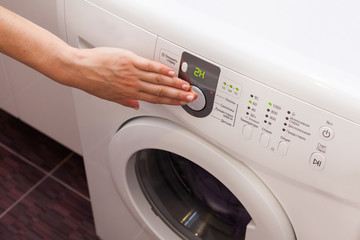 Woman pours the liquid powder in washing machine