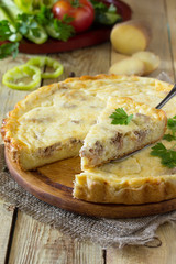 A classic quiche Lorraine pie with potatoes, meat and cheese on