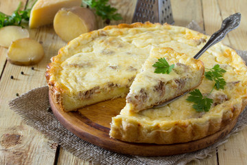 A classic quiche Lorraine pie with potatoes, meat and cheese on