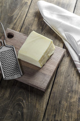 Cheese and grater on a wooden  kitchen table