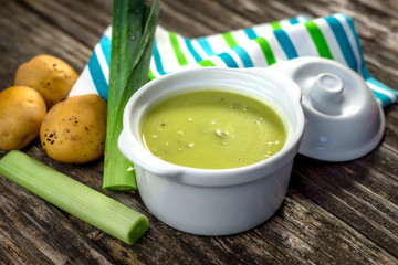 Homemade creamy leek soup on wooden background