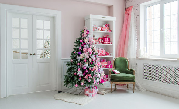 Interior Room Decorated In Christmas Style. No People. An Empty Green Chair. Pink Colors. Home Comfort Of Modern House.