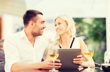 happy couple with tablet pc at restaurant lounge