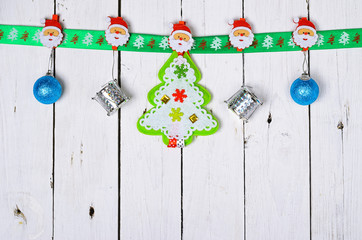 Christmas decorations hanging on a wooden background.