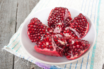 ripe red brushed opened pomegranate on a light background