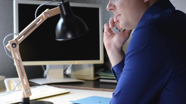 Motivierter Mitarbeiter am Telefon im Homeoffice