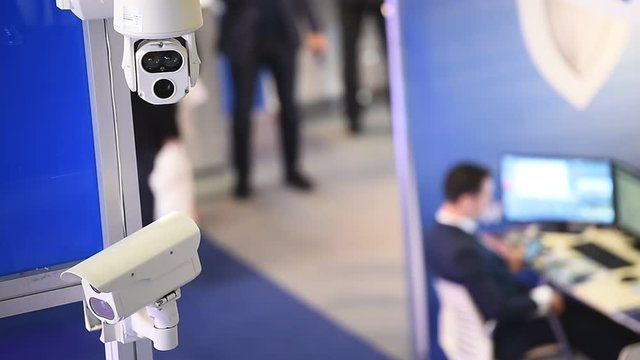 Surveillance camera inside a company with people in the background