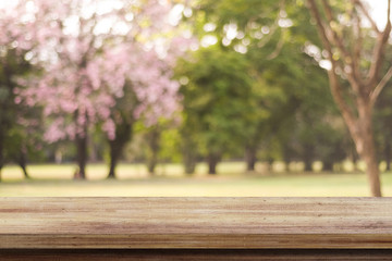 Empty wooden table over blurred tree with bokeh background