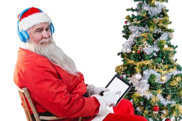 Santa claus using digital tablet with christmas tree