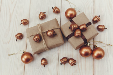 Christmas composition.Present boxes with twine and craft paper,golden acorns and balls.White wooden...