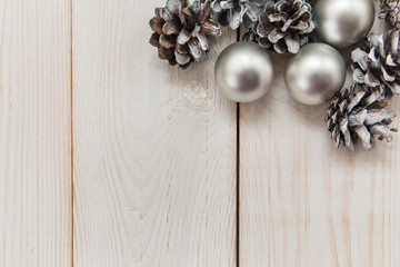 White winter cones on the wooden table with silver balls.Christmas background.Top view