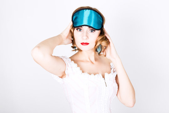 beautiful young woman in pink dress and points for sleep, standing, posing. sleeping eye covering mask