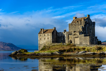 Majestic Eilean Donan castle on beautiful autumn day - with sunny foreground, dramatic sky and amazing scenery