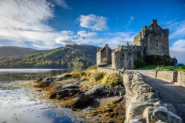 Papier Peint photo autocollant Château Majestic Eilean Donan castle on beautiful autumn day - with sunny foreground, dramatic sky and amazing scenery