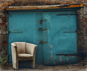 old beige chair in the street at the background of blue wall
