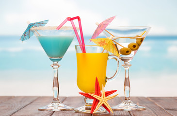 Cocktail, glass juice, alcohol with olives, starfish on background sea.