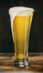 Glass of light beer on a wooden table