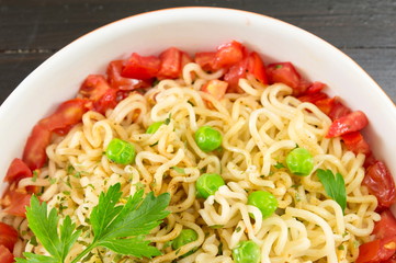 noodles with tomato and peas in a bowl