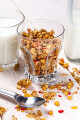 Granola, milk and honey in a glass.