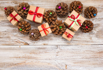 Christmas or New Year background: gifts, colored glass balls, decoration and cones on wooden background