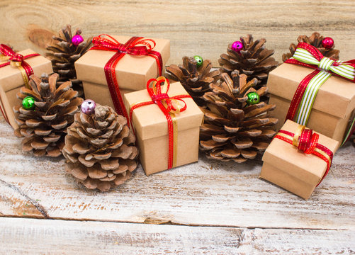 Christmas or New Year background: gifts, colored glass balls, decoration and cones on wooden background