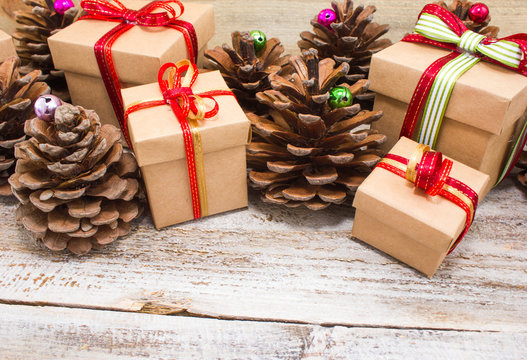 Christmas or New Year background: gifts, colored glass balls, decoration and cones on wooden background