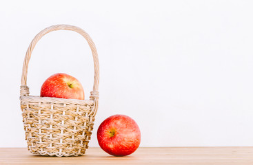 Apples in basket on wooden table