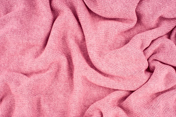 close up pink knitted pullover background. Top view.