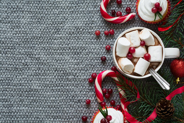 Christmas decoration. Hot chocolate with marshmallow on grey knitted background