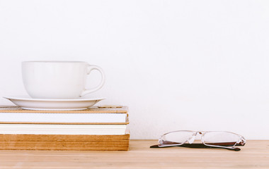 Book and eyeglasses on wood background