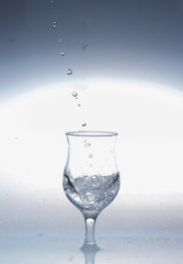  water is poured from a bottle into a glass