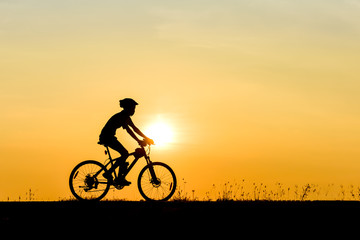 Fototapeta na wymiar Silhouette of cyclist motion on sunset background