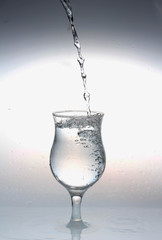  water is poured from a bottle into a glass