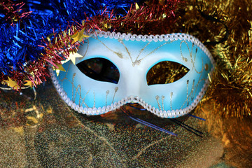 Brilliant blue carnival mask close up on shiny background with festive colored garlands
