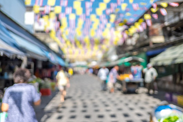 Blurred background : people shopping at market fair in sunny day